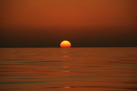 Einzig schÃ¶n an der Windstille - die untergehende Sonne spiegelt sich im ruhigen Meer.