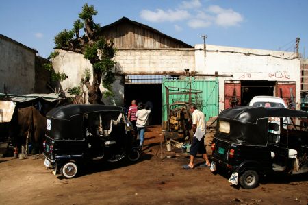 Mit dem Tuk-Tuk fahren Wolfang, RÃ¼diger und der Agend zum Autowerkstatt.