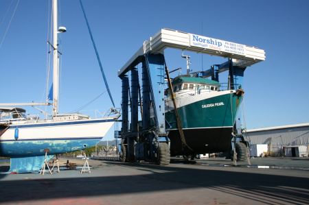 groÃŸe Fischerboote werden Zug um Zug zu Wasser gelassen.